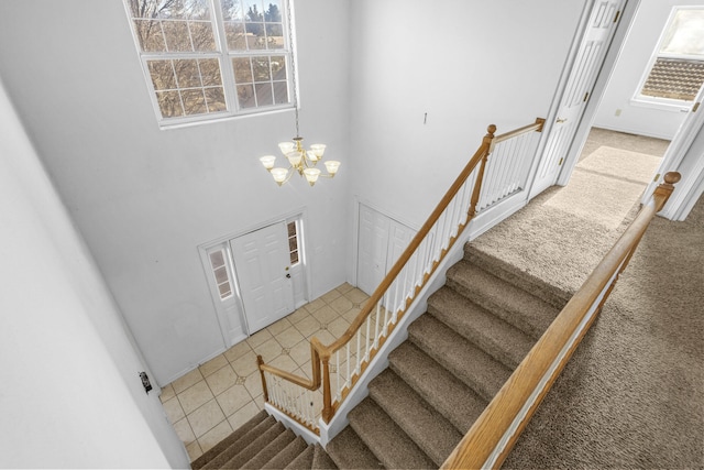 stairs with a high ceiling and an inviting chandelier