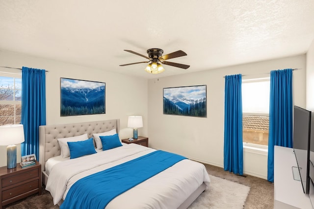 carpeted bedroom featuring ceiling fan and a textured ceiling