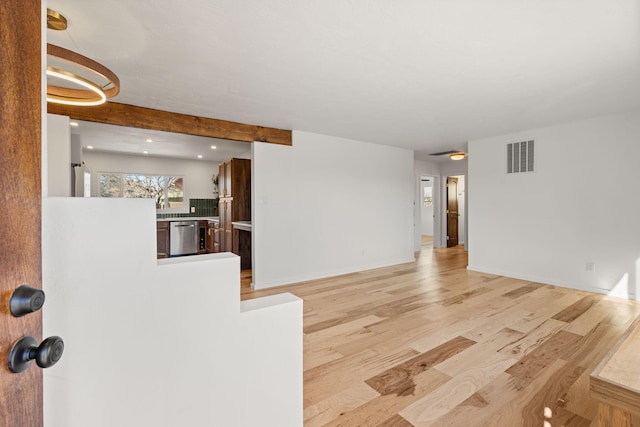 living room featuring beamed ceiling and light wood-type flooring