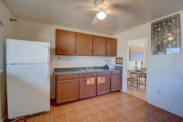 kitchen with ceiling fan, white refrigerator, and sink