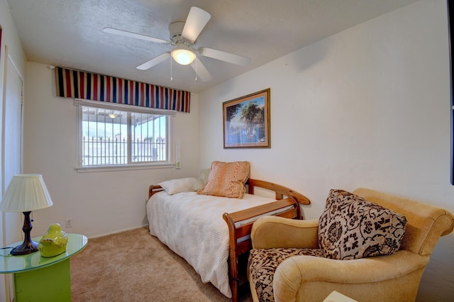 bedroom with ceiling fan, light colored carpet, and a textured ceiling