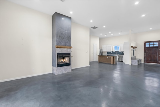 unfurnished living room featuring a multi sided fireplace