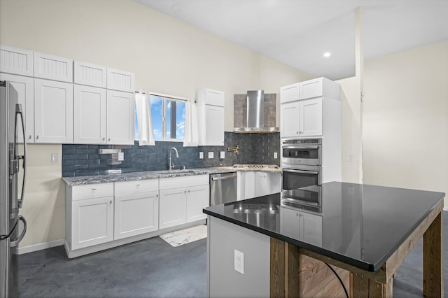 kitchen with sink, white cabinetry, a center island, wall chimney range hood, and stainless steel appliances