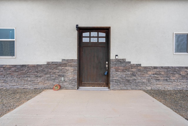 view of exterior entry featuring a patio area