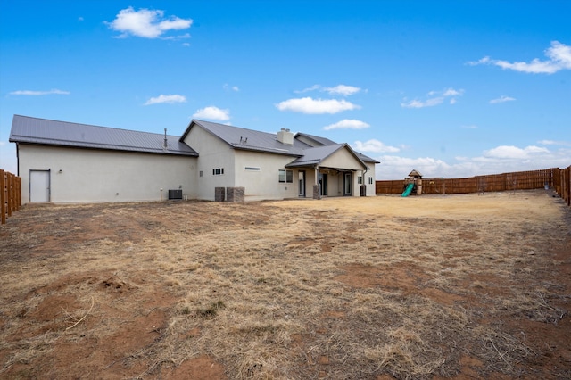 back of house featuring a playground and central AC