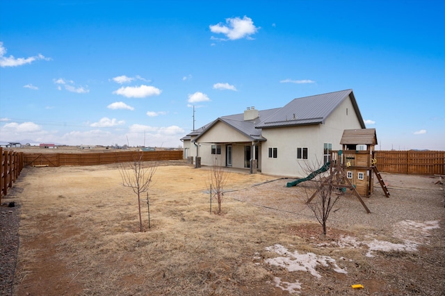 back of house with a playground