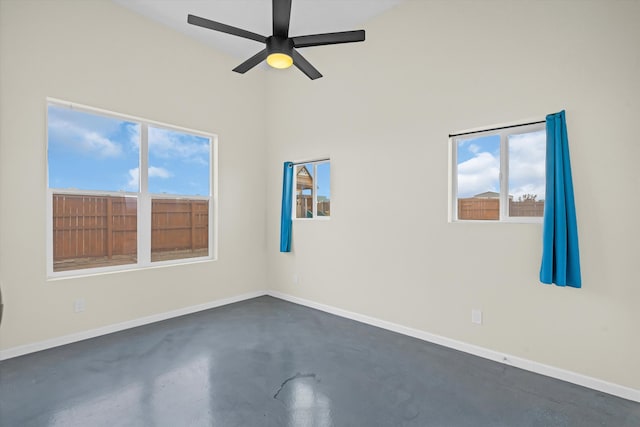 empty room featuring ceiling fan and a wealth of natural light