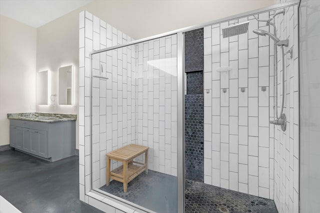 bathroom with concrete floors, vanity, and a tile shower