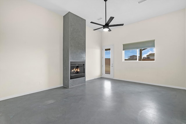 unfurnished living room featuring ceiling fan and a large fireplace