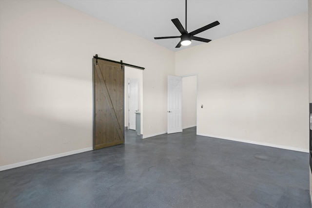 empty room with ceiling fan and a barn door