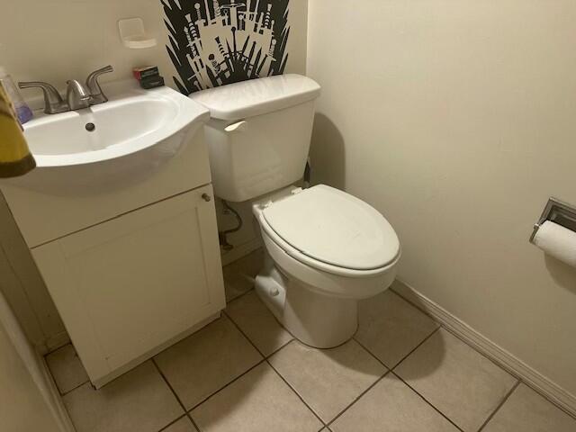 bathroom with toilet, vanity, and tile patterned floors