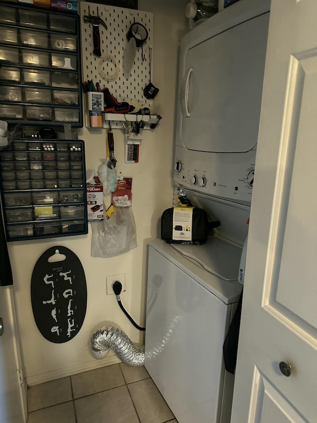 laundry room with stacked washer and dryer and tile patterned flooring