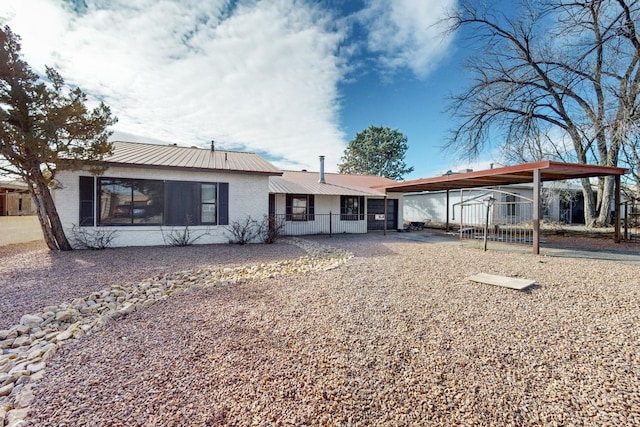 back of house featuring a carport