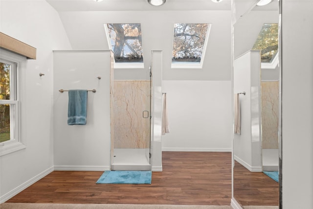 bathroom featuring wood-type flooring and vaulted ceiling