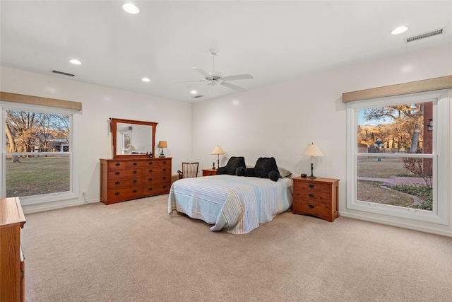 bedroom with ceiling fan and light colored carpet