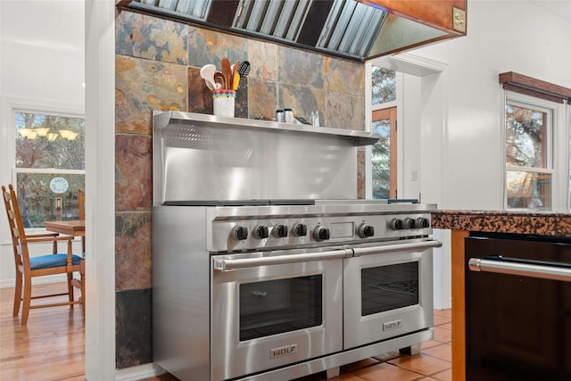 kitchen with luxury stove, light tile patterned floors, and dishwasher