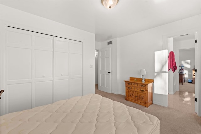 bedroom featuring light colored carpet and a closet