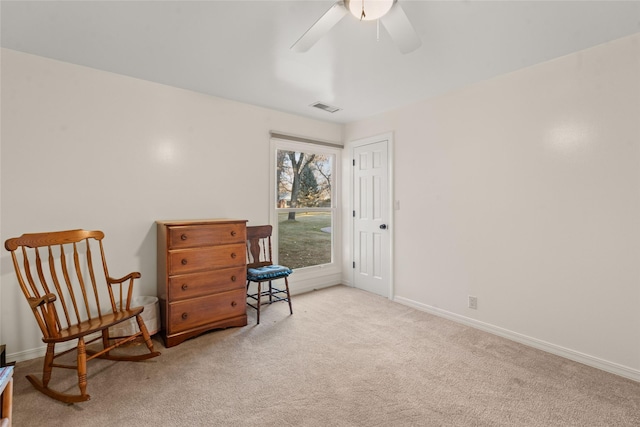 living area featuring ceiling fan and light colored carpet