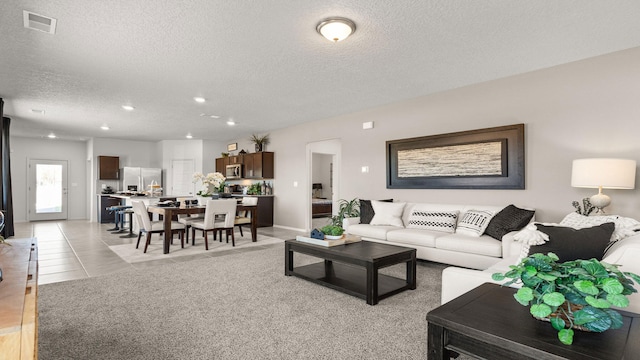 tiled living room featuring a textured ceiling