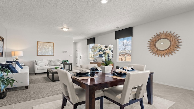 tiled dining room with a textured ceiling