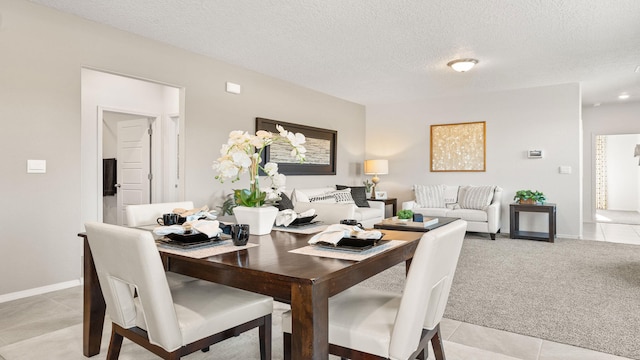 carpeted dining area featuring a textured ceiling