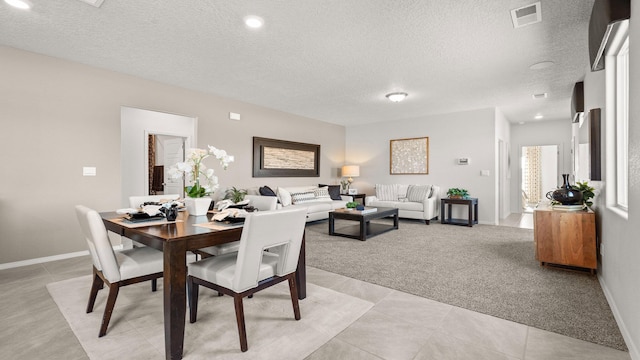 dining space with light carpet and a textured ceiling