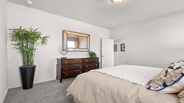 bedroom with light colored carpet and a textured ceiling