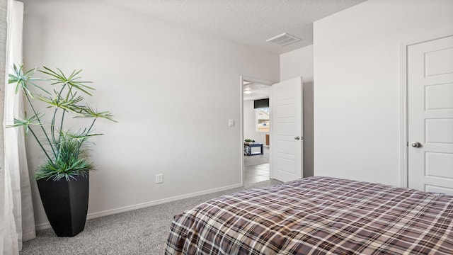 carpeted bedroom featuring a textured ceiling