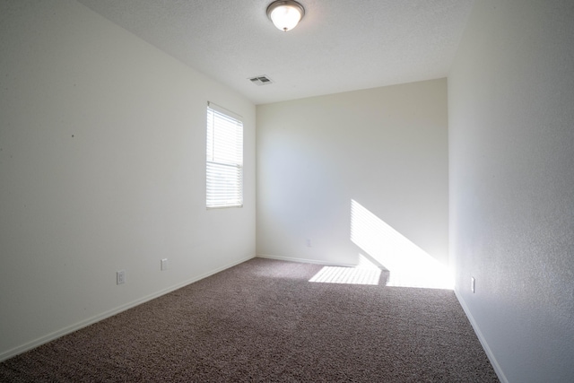 unfurnished room with a textured ceiling and carpet flooring