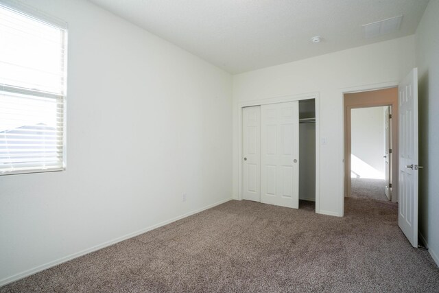 unfurnished bedroom featuring a closet and carpet floors