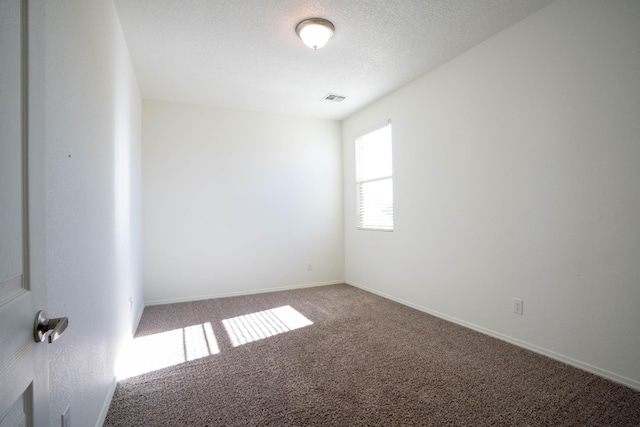 unfurnished room featuring a textured ceiling and carpet floors