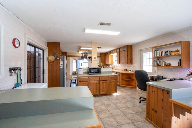 kitchen with appliances with stainless steel finishes, kitchen peninsula, and decorative backsplash