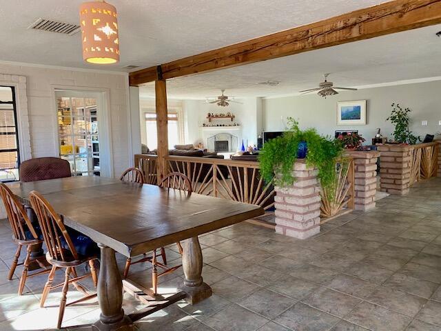 dining space with crown molding, ceiling fan, and beam ceiling