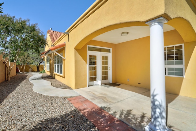 view of exterior entry with french doors and a patio