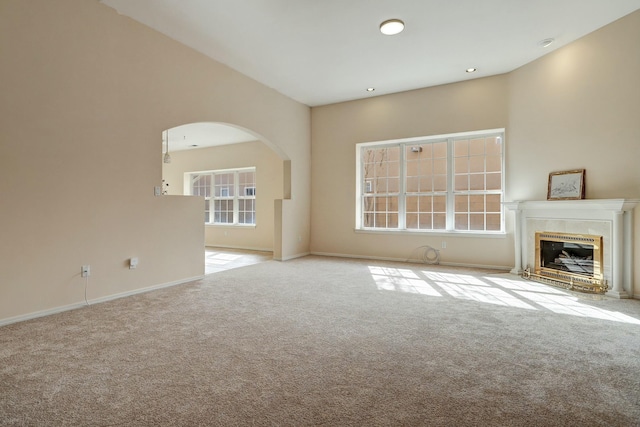 unfurnished living room featuring a tile fireplace and light carpet