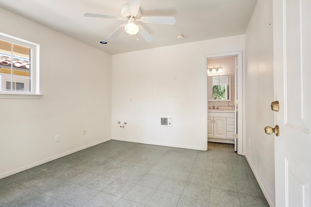 unfurnished room with ceiling fan and sink