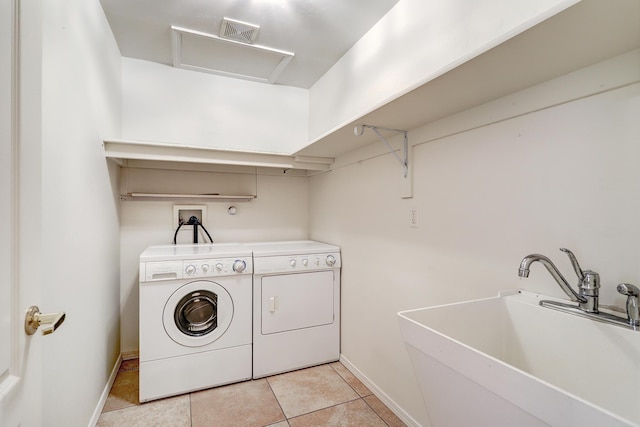 washroom featuring sink, washing machine and clothes dryer, and light tile patterned floors