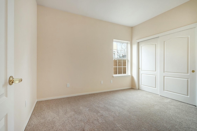 unfurnished bedroom with light colored carpet and a closet