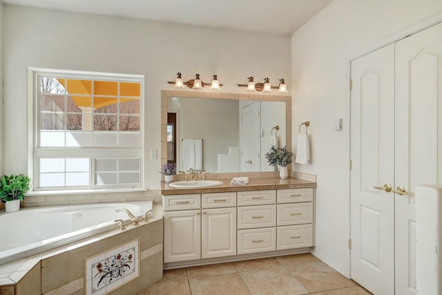 bathroom featuring tile patterned floors, tiled tub, and vanity