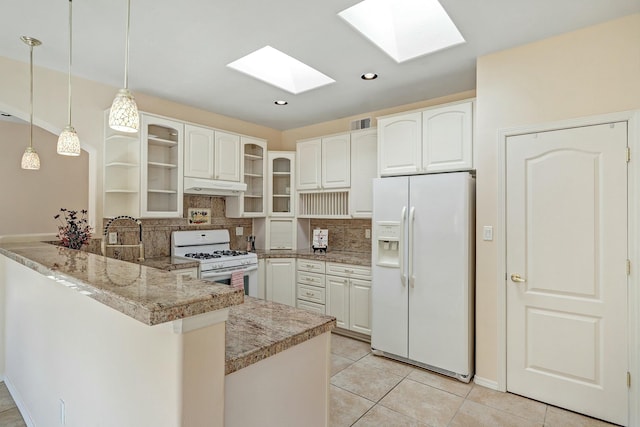 kitchen with white appliances, hanging light fixtures, white cabinets, kitchen peninsula, and backsplash