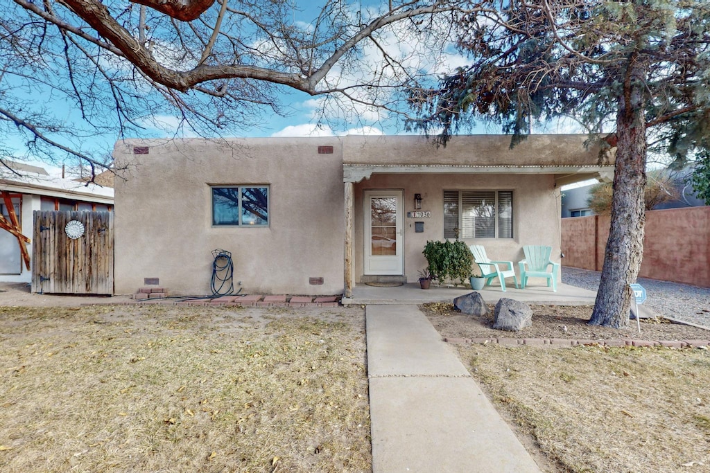 pueblo revival-style home with a front yard