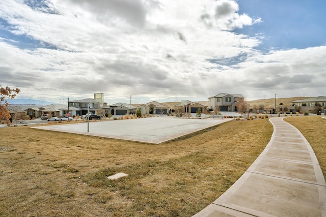 view of property's community featuring basketball court and a lawn