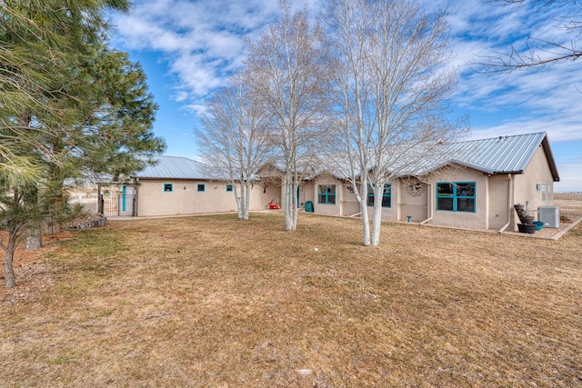 rear view of property featuring a yard and central air condition unit