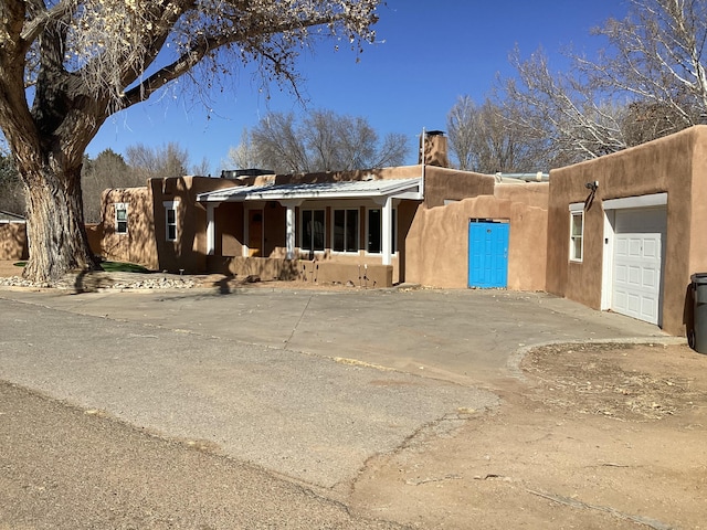 pueblo revival-style home with a garage