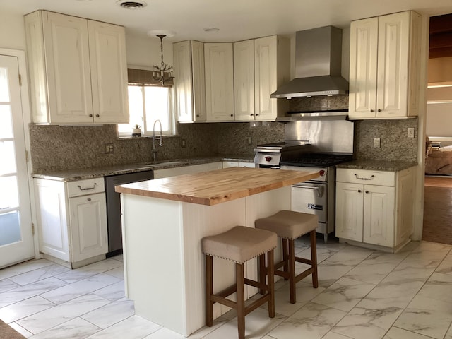 kitchen with wall chimney range hood, a breakfast bar area, stainless steel appliances, a kitchen island, and wood counters