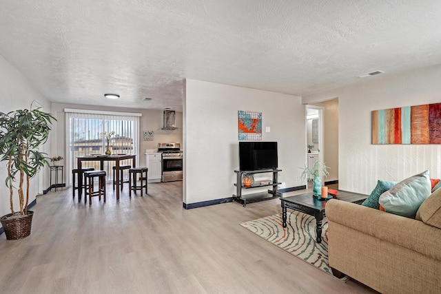 living room with light hardwood / wood-style floors and a textured ceiling