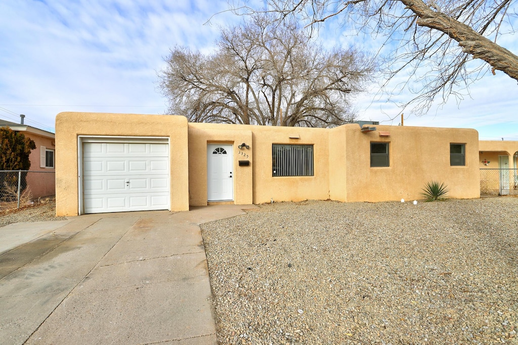 pueblo-style house featuring a garage