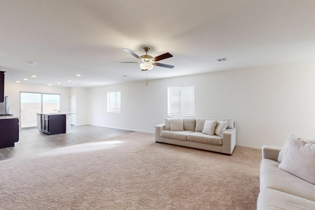 carpeted living room with ceiling fan and a wealth of natural light