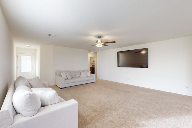 carpeted living room featuring ceiling fan