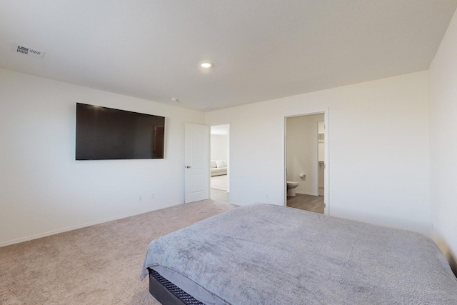 bedroom featuring light colored carpet and connected bathroom